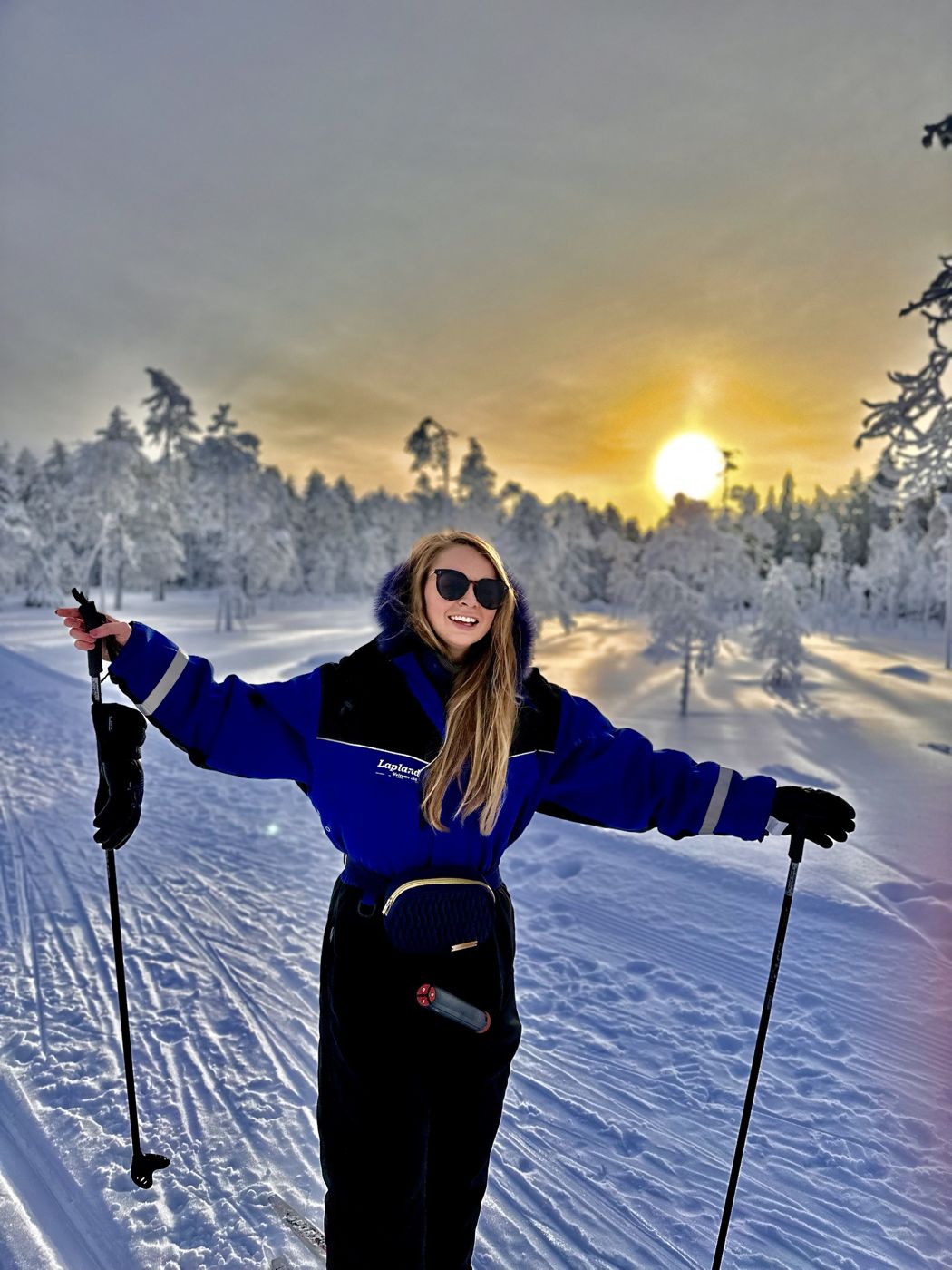 Berenice smiling while cross-country skiing in Lapland at sunset