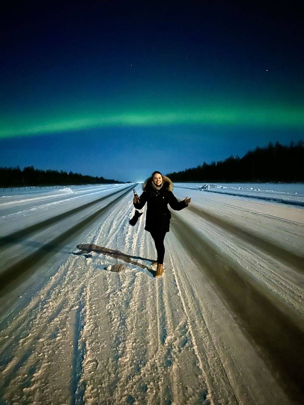 The northern lights over a snowy road in Lapland
